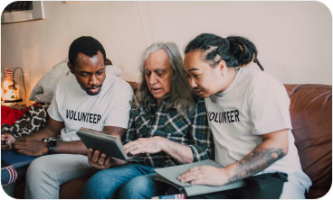 Volunteers helping senior with digital support at charity organization