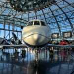 Vintage and modern aircraft displayed inside a glass-domed aviation museum hangar