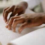 A person reading Braille, representing accessible literacy supported by charities listed on CharityAxess for people with disabilities