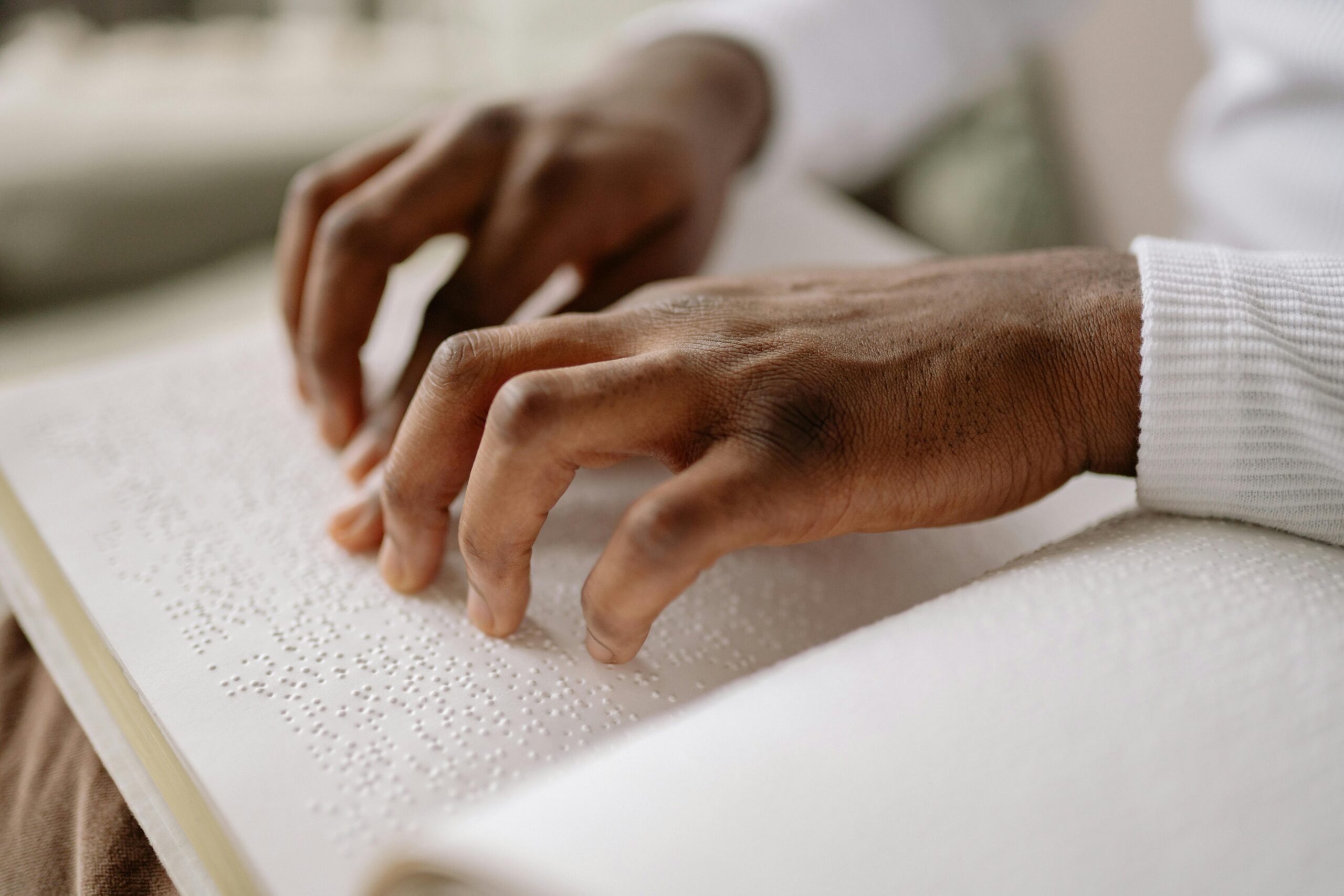 A person reading Braille, representing accessible literacy supported by charities listed on CharityAxess for people with disabilities