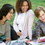 Group of young people sitting outdoors and studying together, representing youth collaboration and mental health support in British Columbia.