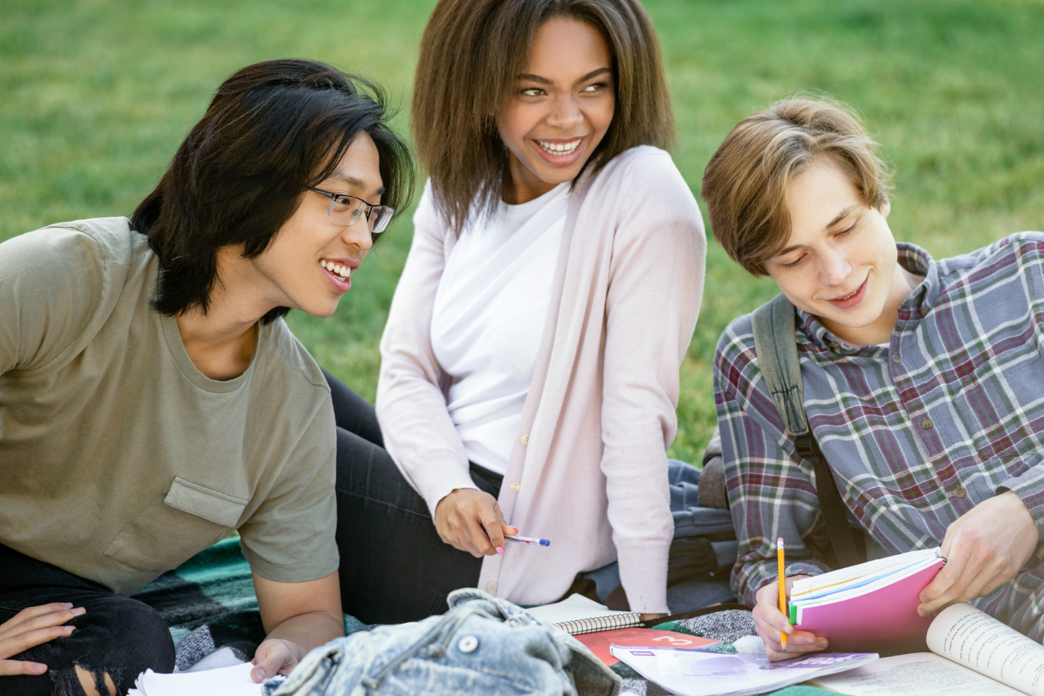 Group of young people sitting outdoors and studying together, representing youth collaboration and mental health support in British Columbia.