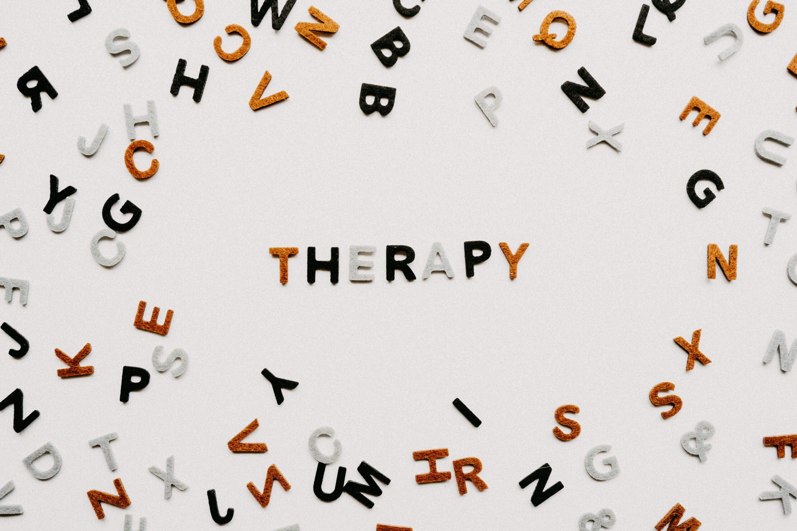 The word therapy spelled with colorful letters on a white background representing mental health support in Ontario