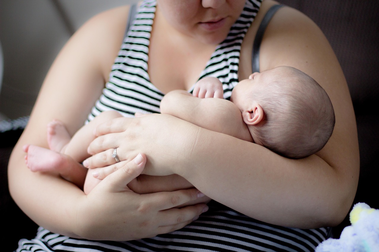 Mother holding her newborn while receiving postpartum support from charities in Canada