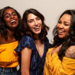 Three women smiling together, representing community support and women&rsquo;s health initiatives supported by charities in Canada