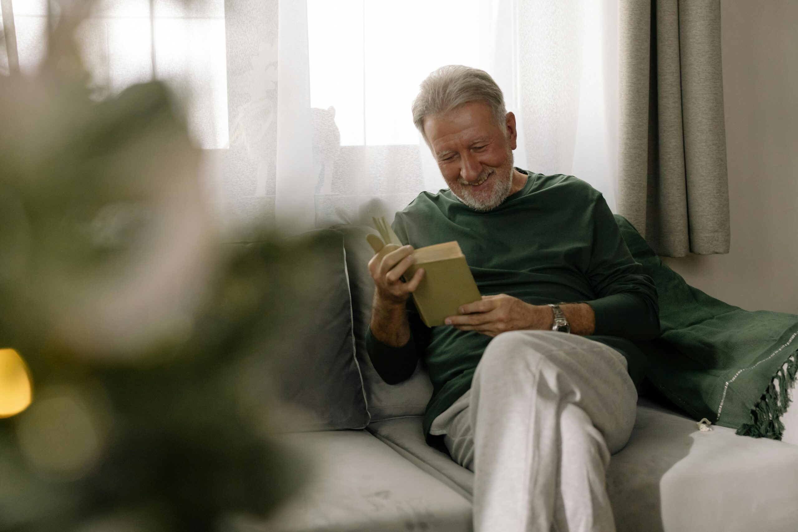 Older man sitting comfortably in a furnished apartment, representing successful housing support from a Montreal homeless shelte