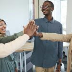 Diverse group of adults smiling and high-fiving during a supportive community meeting in Quebec