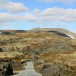 Winding road through a rugged Newfoundland landscape under a blue sky