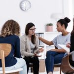 Women participating in a group therapy session as part of addiction recovery support offered by community charities in Alberta, Canada