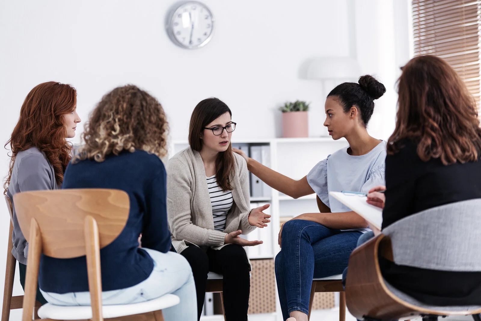 Women participating in a group therapy session as part of addiction recovery support offered by community charities in Alberta, Canada